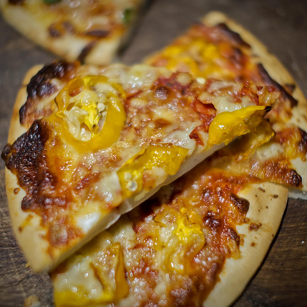  World of Chillies: Slices of homemade pizza topped with yellow Jamaican Hot chillies and melted golden cheese. 