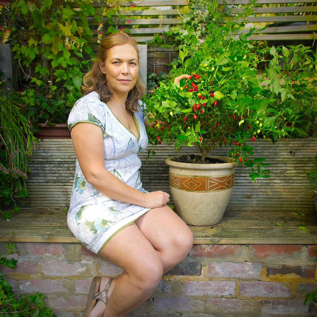World of Chillies grower beside potted Biquinho chilli plant